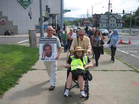 Jack Gilroy Pushes The Blister-Footed Wife, Steve Downs And Yassin Aref March Alongside