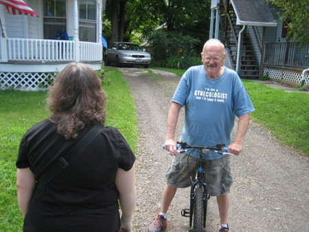 Stan Knapp, Former Sidney Police Chief Called For Rescue When He Heard The Wife Scream.  Yes, His T-Shirt Reads, "I'm Not A GYNECOLOGIST But I'll Be Glad To Take A Look."