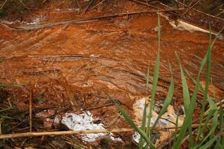 Water Tainted With Orange Leachate From The Dump